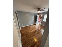 Open living room with hardwood floors, ceiling fan, and an open door leading to the outside at 571 Formwalt Sw St # 7, Atlanta, GA 30312