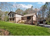 Charming home with brick and tudor accents, lush lawn, and mature trees at 2080 Silversmith Ln, Stone Mountain, GA 30087