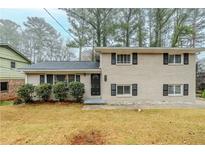 Charming two-story home with a classic brick exterior, complemented by black shutters and lush front yard landscaping at 2916 Lloyd Rd, Decatur, GA 30034