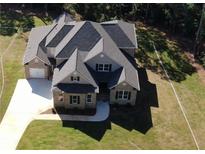 Aerial view of a beautiful two-story home with a large, well-manicured lawn and an attached garage at 8033 White Stone Blvd, Douglasville, GA 30135