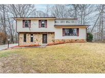 Charming home with stone accents and shuttered windows surrounded by a beautiful wooded landscape at 3998 Chimney Ridge Dr, Ellenwood, GA 30294