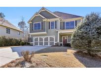 Charming two-story home with a well-manicured lawn, a two-car garage and neutral colored shutters at 8265 Majors Glen Ct, Cumming, GA 30041