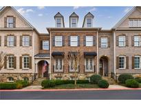 Charming brick townhome with black awnings, dormer windows, and manicured landscaping at 2368 Saint Davids Nw Sq # 4, Kennesaw, GA 30152
