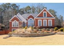 Charming red brick home with manicured lawn and detailed landscaping at 725 First Cotton Dr, Powder Springs, GA 30127
