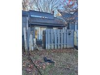Exterior of home featuring a small gated yard space with damaged fence in need of repair at 4707 Mariners Way, Stone Mountain, GA 30083