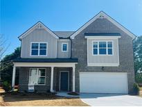 Charming two-story home with a two-car garage, brick facade, and a beautifully landscaped front yard at 1856 Kingsmere Run Dr, Loganville, GA 30052