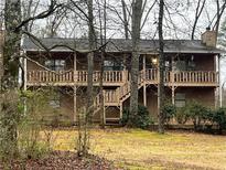 Charming two-story cabin home with wood siding, dual balconies, and a chimney, nestled among the trees at 25 Chestnut Ridge Ne Dr, Cartersville, GA 30121