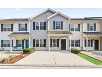 Charming two-story townhome with a well-maintained exterior, black shutters and a concrete driveway at 129 Prospect Path, Hiram, GA 30141