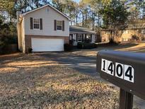 Split-level home featuring a two-car garage and mailbox displaying 1404 at 1404 Bailey Sw, Conyers, GA 30094