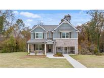 Charming two-story home with brick and blue siding and a well-manicured lawn at 1847 Kingsmere Run Dr, Loganville, GA 30052