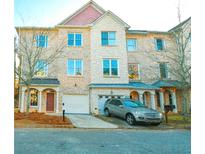 Charming brick townhome featuring a two-car garage and well-manicured landscaping at 4879 Pinnacle Dr, Stone Mountain, GA 30088