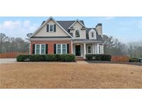 Charming two-story home with a brick and vinyl exterior, complemented by a well-maintained front yard and mature landscaping at 1008 Walnut Creek Dr, Woodstock, GA 30188