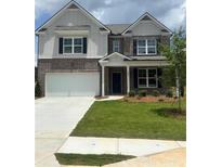 Charming two-story home with a brick facade, attached two-car garage, and well-manicured lawn at 1857 Kingsmere Run Dr, Loganville, GA 30052