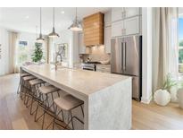 Bright kitchen boasts a large island, modern appliances, pendant lighting and hardwood floors at 519 Motivation Nw Cir # 0011, Atlanta, GA 30309
