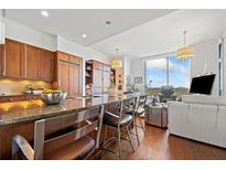Bright kitchen features dark wood cabinetry, granite counters, a large island with seating, and views at 3630 Peachtree Ne Rd # 1809, Atlanta, GA 30326