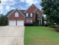 Beautiful two-story brick home featuring a two-car garage and a well-manicured front lawn at 4856 Planters Walk, Douglasville, GA 30135