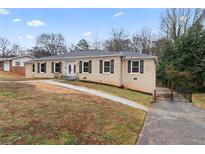 Charming brick ranch-style home with black shutters, a well-maintained yard, and inviting curb appeal at 2427 Kings Park Cir, Decatur, GA 30034