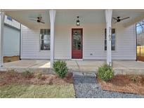 Inviting front porch featuring a red door, ceiling fans and crisp, white columns at 3163 Old Jonesboro Rd, Hapeville, GA 30354
