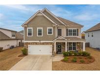 Charming two-story home featuring stone accents, a two-car garage, and a well-maintained front lawn at 4480 Sunflower Cir, Cumming, GA 30040
