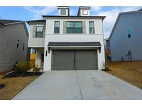 Charming two-story home with a white brick facade, grey shutters, a two-car garage and a well-manicured lawn at 51 Station Overlook Way, Auburn, GA 30011