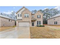 Traditional two-story brick home with a two-car garage and manicured front lawn at 116 Cabin Way, Hampton, GA 30228