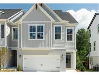 Charming two-story home featuring a white brick base, gray siding, and a two-car garage at 1255 Windmill Pkwy, Cumming, GA 30041