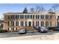 Three-story brick condo building with black shutters, well-maintained landscaping, and convenient parking at 1101 Collier Nw Rd # R3, Atlanta, GA 30318