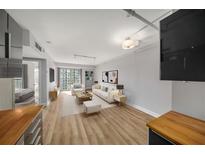 Bright living room featuring hardwood floors, neutral paint, and sliding glass doors to balcony at 199 14Th Ne St # 2407, Atlanta, GA 30309
