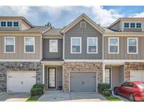 Charming townhome with stone accents, gray siding, and a two-car garage at 5036 Longview Walk, Decatur, GA 30035