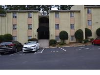 The exterior of this tan two-story condominium building features a dark awning and visitor parking at 2398 Lawrenceville Hwy # K, Decatur, GA 30033
