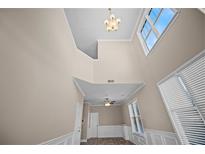 Bright living room features high ceilings, a modern chandelier, and many windows at 4861 Pinnacle Dr, Stone Mountain, GA 30088