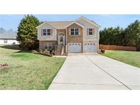 Charming two-story home featuring a brick facade, two-car garage, and well-maintained lawn at 7235 Magnolia Ln, Fairburn, GA 30213