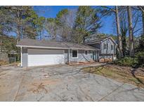 Charming gray house with an attached garage and a concrete driveway at 4391 Shiloh Hills Dr, Snellville, GA 30039