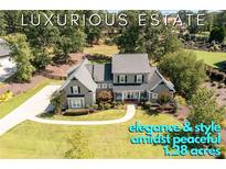 Stunning gray home with manicured lawn, elegant walkway, and surrounded by lush trees on 1.28 acres at 276 Red Gate Dr, Canton, GA 30115