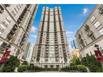 Tall apartment building with balconies and manicured landscaping against a bright blue sky at 195 14Th Ne St # 312, Atlanta, GA 30309