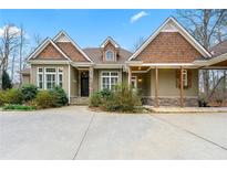 Charming home featuring stone accents, covered porch, and mature landscaping with circular driveway at 30 Crolley Ln, White, GA 30184
