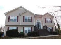Charming two-story home featuring neutral siding, symmetrical windows with red shutters, and an inviting entry stairway at 705 Freeman Dr, Covington, GA 30016