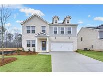 Beautiful two-story white brick home featuring an attached garage, manicured lawn, and charming curb appeal at 6096 Marigold Way, Atlanta, GA 30349