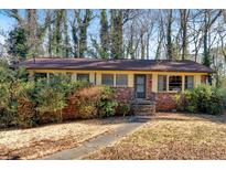 Charming brick ranch home with manicured lawn, sidewalk, and mature trees surrounding the property at 2361 Wakita Se Ct, Marietta, GA 30060