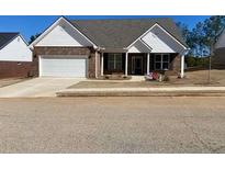 Charming single-story home featuring a brick facade and a well-manicured lawn at 911 Park Place St, Social Circle, GA 30025