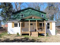 Charming renovated home featuring a quaint front porch with wood columns and railings and painted white brick at 1285 Mcclure Nw Ave, Atlanta, GA 30314
