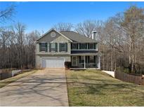 Charming two-story home features a two-car garage, green shutters, and well-maintained landscaping at 212 Oak Grove Dr, Hampton, GA 30228