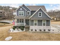 Charming gray two-story home featuring a welcoming front porch and beautiful landscaping at 15 Lakeside Way, Cartersville, GA 30121