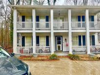 Charming two-story exterior of a house showcasing double porches with white columns and railings at 1790 Whitley Rd, Dacula, GA 30019