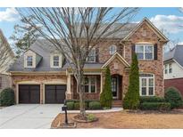 Charming two-story brick home featuring a well-manicured lawn and attached two-car garage at 822 Pistace Ct, Alpharetta, GA 30022