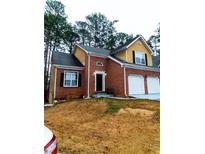Charming brick home featuring a two-car garage and manicured front lawn at 3812 Maclaren Dr, Clarkston, GA 30021