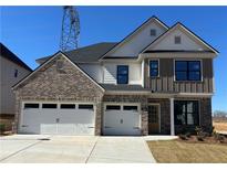 A traditional two-story home featuring a brick and siding facade, a three-car garage, and a well-manicured lawn at 4024 Hosch Retreat Dr, Buford, GA 30519