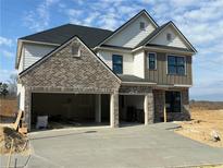 New two-story home boasts a three car garage and a classic brick and siding facade at 4024 Hosch Retreat Dr, Buford, GA 30519