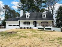 Charming home featuring dormer windows, attached two-car garage and a cozy front porch at 2705 Old Ivy Ct, Buford, GA 30519