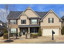 Charming two-story home featuring a two-car garage and a welcoming front porch at 651 Deer Springs Way, Loganville, GA 30052